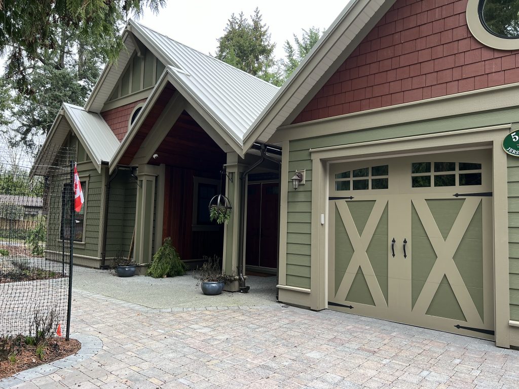 An exterior of a house with red and green siding and taupe trim.