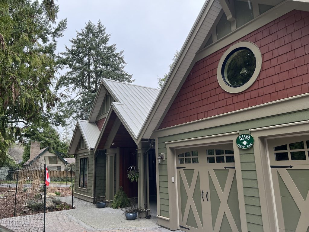 An exterior of a house with red and green siding and taupe trim.